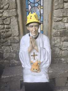 a statue of a priest with a pikachu hat on his head