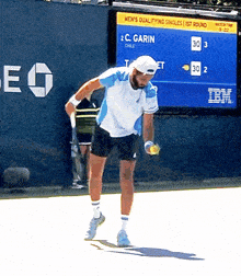 a man is playing tennis in front of a scoreboard that says " men 's qualifying singles 1st round "