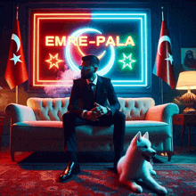 a man in a suit sits on a couch in front of a sign that says emre-pala