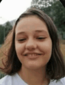 a close up of a girl 's face with her eyes closed and smiling .