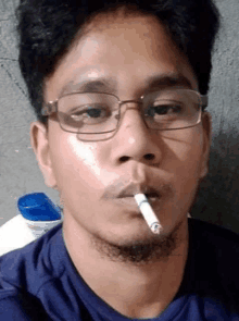 a man with glasses is smoking a cigarette .