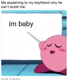 kirby is holding a sign that says ' im baby ' on it