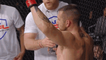 a man with a tattoo on his back is being helped by another man