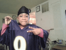 a young boy wearing a purple jersey with the number 0 on it