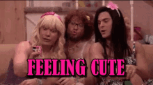 a group of men dressed as women are sitting on a couch with the words feeling cute above them .