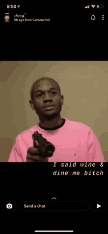 a man in a pink shirt is holding a gun and says i said wine & dine me bitch