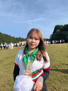 a woman stands in a field wearing a lanyard that says ' saigon ' on the front