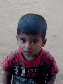 a young boy is wearing a red shirt that says go to war