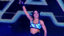 a woman is dancing on a stage with her arms in the air .