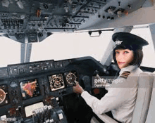 a woman is sitting in the cockpit of a plane .