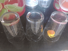 three empty glasses are sitting on a table next to a bottle of coca cola