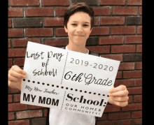 a boy holds up a sign that says last day of school