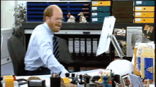 a man sitting at a desk in front of a computer with a binder that says ' o'neill ' on it