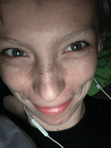 a close up of a person 's face with freckles and headphones