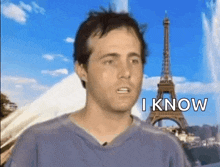 a man is standing in front of the eiffel tower with the words `` i know '' written on his face .