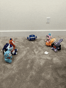 a group of stuffed animals are playing with a football that says denver broncos on it