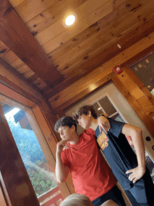 two boys standing next to each other one of whom is wearing a shirt that says ' chicago bulls ' on it