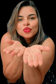 a woman blowing a kiss with her hands