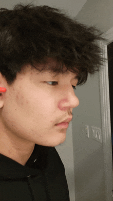 a man with a red spot on his nose is wearing ear buds