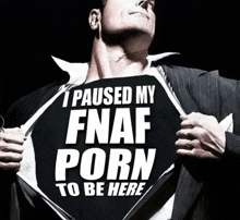 a man in a suit holds up a sign that says i paused my fnaf porn to be here