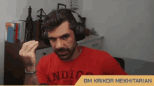 a man wearing headphones and a red shirt with indigo written on it