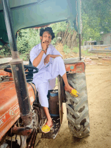 a man sits on a red tractor that says ford