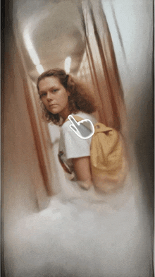 a woman with a yellow backpack is in a hallway