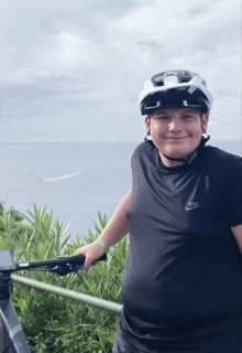 a boy wearing a helmet and a nike shirt smiles