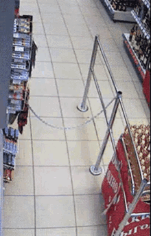 a chain is attached to a metal pole in a store aisle