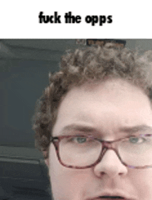 a man with curly hair and glasses is making a funny face and says fuck the opps .