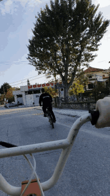 a man is riding a bike down a street in front of a building that says ' labo ' on it