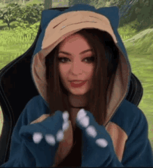 a woman is wearing a hoodie that looks like a pokemon and has headphones on .