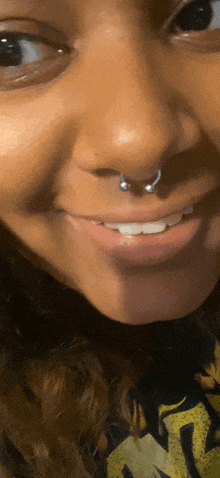 a close up of a woman 's face with a nose ring on it