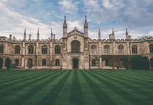 a large old building with a lush green lawn in front of it