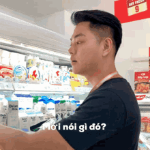 a man in a black shirt is standing in front of a display of dairy products with a sign that says sky fresh 9