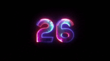 the number 26 is glowing in the dark and changing colors .
