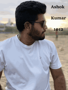 a man wearing sunglasses and a white shirt has the name ashok kumar 1012 on the bottom