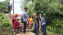 a man in a blue shirt with the word crew on it is standing next to a group of people