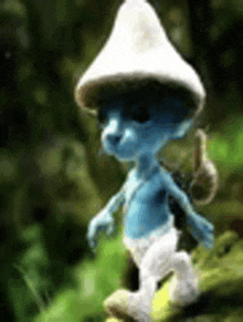 a blue smurf wearing a white hat and carrying a backpack is walking through a forest .