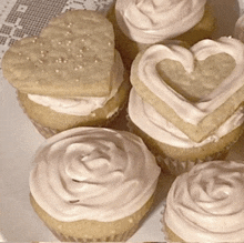 a heart shaped cookie sits on top of a cupcake