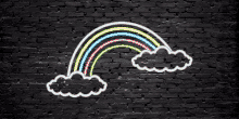 a neon sign of a rainbow and clouds on a brick wall