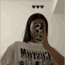 a woman is taking a selfie in front of a mirror with her phone .