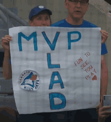 a toronto blue jays fan holds a sign that says mvp lad