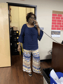 a woman is talking on a phone in front of a sign that says no smoking