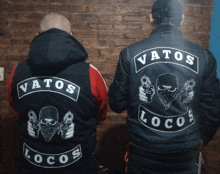 two men wearing jackets that say vatos locos on the back