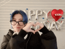 a person making a heart with their hands in front of balloons that say happy birthday yuma