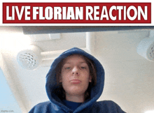 a person wearing a blue hoodie stands in front of a sign that says " live florian reaction "