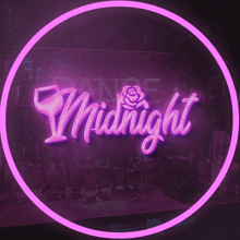 a neon sign that says midnight with a glass and rose