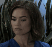 a woman in a blue scrub top looks down at something