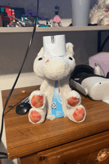 a stuffed animal is sitting on a wooden table next to a spray bottle